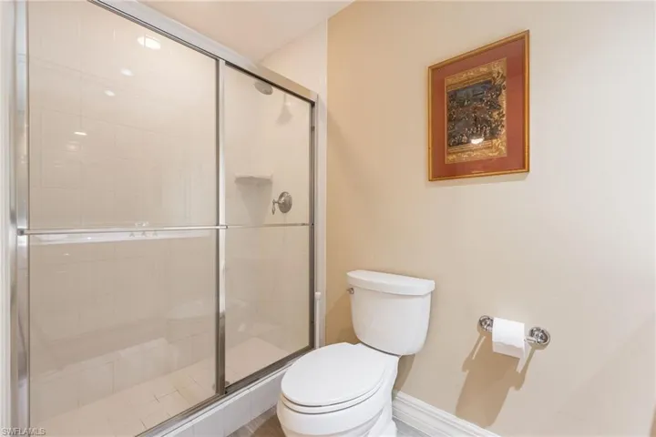 Full bath with white tile to ceiling in shower