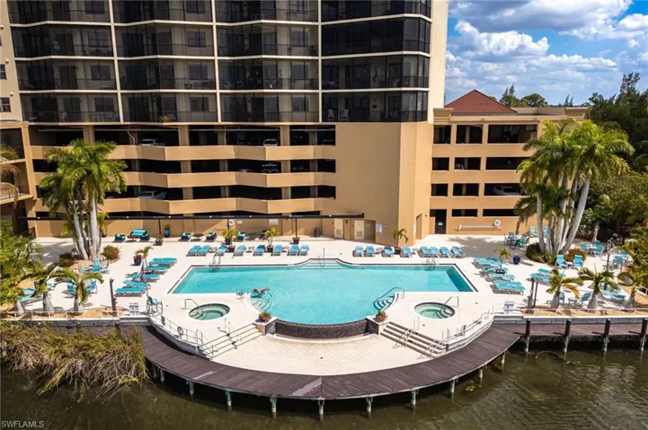 Community Resort pool featuring two hot tubs, and a boardwalk by the lake.