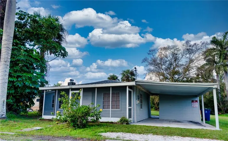 View of front facade featuring a sunroom and a carport