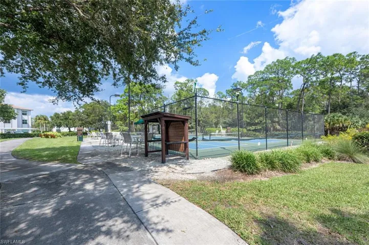 View of sport court with a lawn