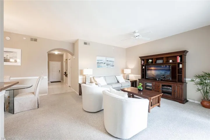 Carpeted living room featuring ceiling fan
