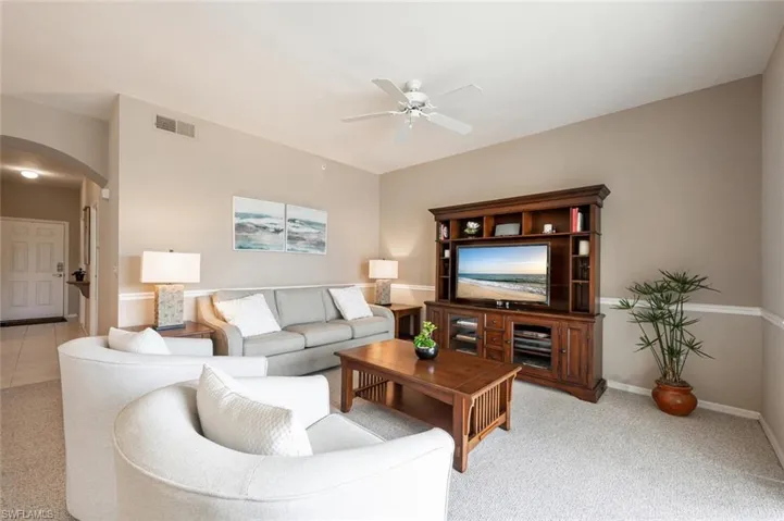 Living room featuring light carpet and ceiling fan