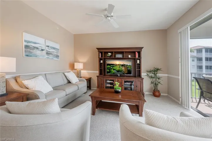 Living room featuring ceiling fan and carpet flooring