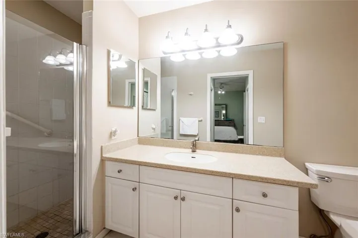 Bathroom with walk in shower, vanity, and toilet