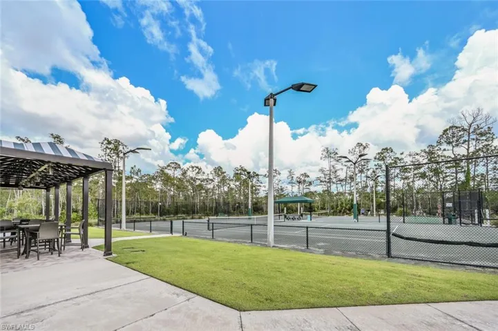 View of sport court with a yard