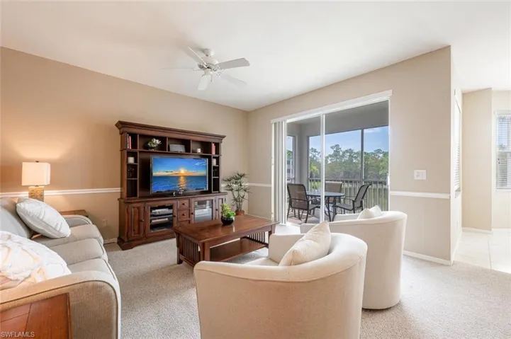Carpeted living room with ceiling fan