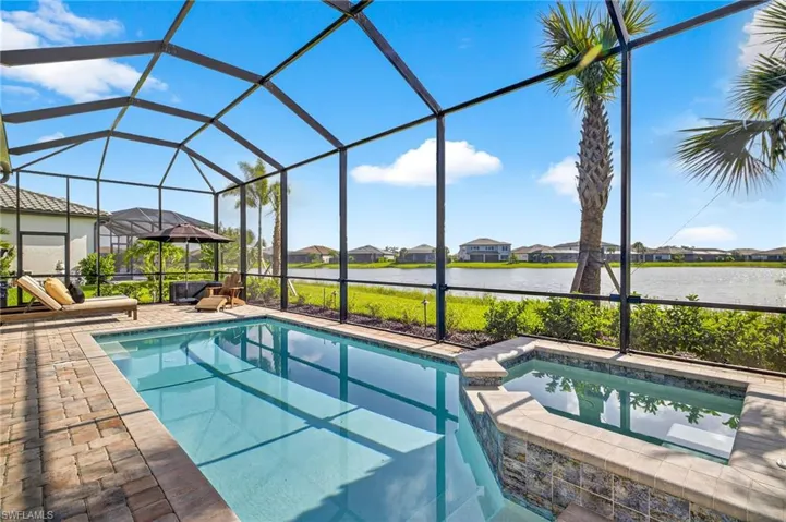 View of green lawn featuring a residential view, a water view, and glass enclosure