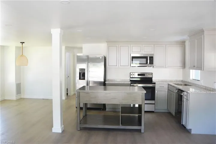 Modern luxury meets coastal charm: Step into culinary bliss with the newly remodeled kitchen featuring state-of-the-art appliances in this idyllic lakeside retreat.