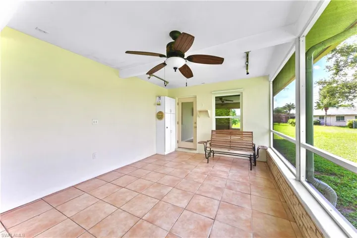 Unfurnished sunroom with rail lighting and ceiling fan