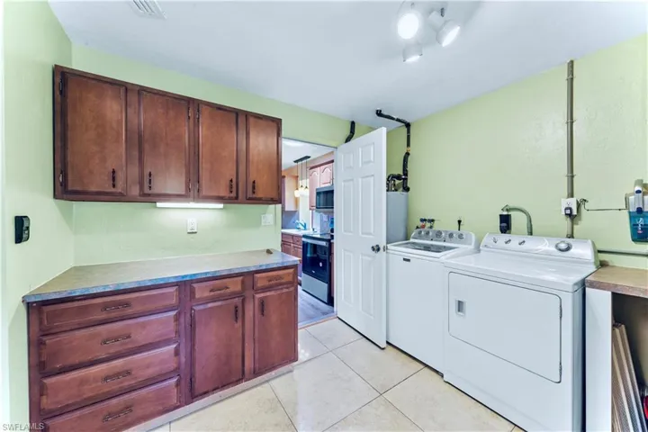 Washroom featuring separate washer and dryer and light tile patterned floors