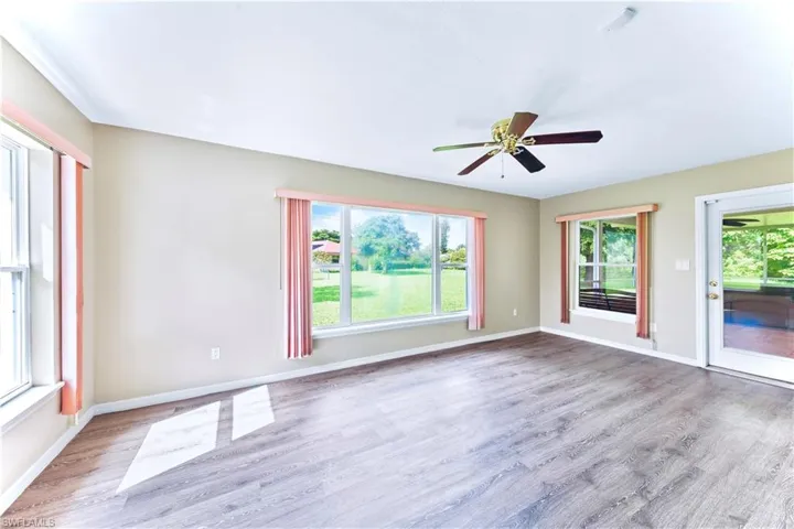 Spare room with ceiling fan, a wealth of natural light, and light hardwood / wood-style flooring