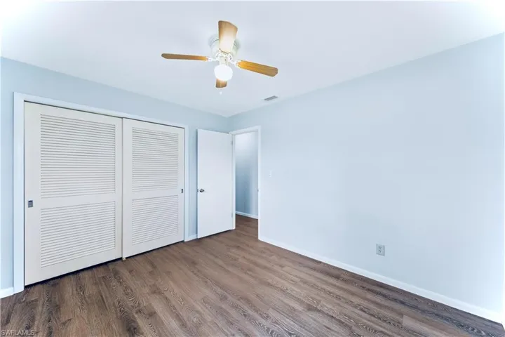 Unfurnished bedroom featuring a closet, ceiling fan, and dark hardwood / wood-style floors