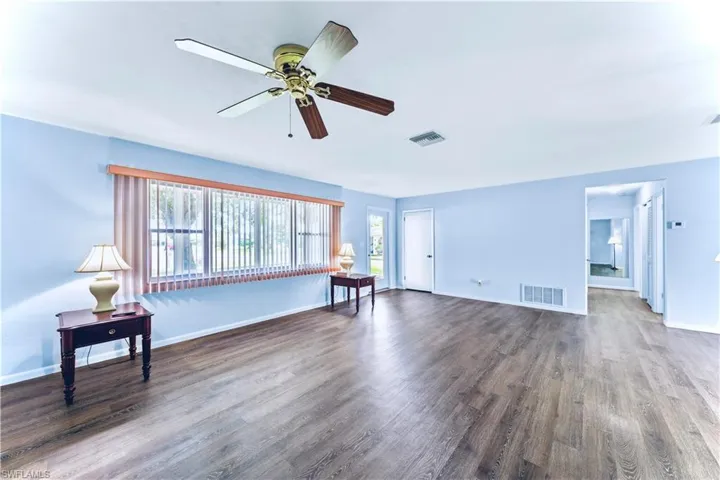 Unfurnished living room featuring wood-type flooring and ceiling fan