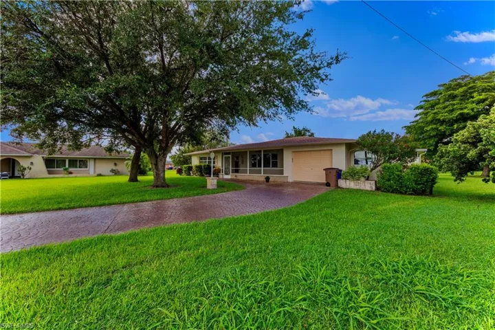 Single story home with a garage and a front yard