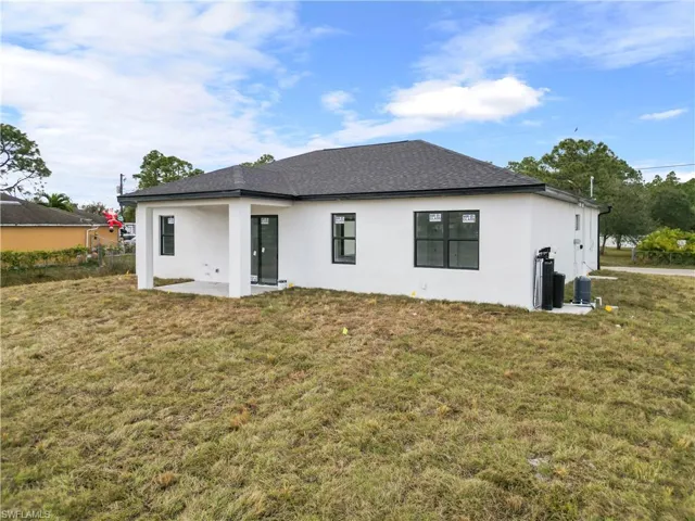 Back of property with a lawn and a patio