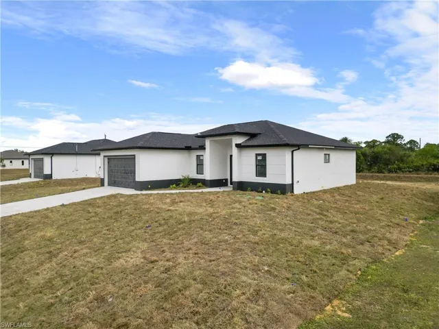 View of front facade featuring a front yard and a garage
