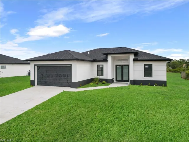 Prairie-style home with a garage and a front lawn
