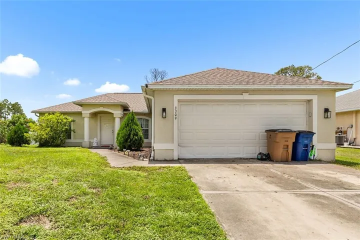 Single story home with stucco siding, driveway, a front lawn, and a garage