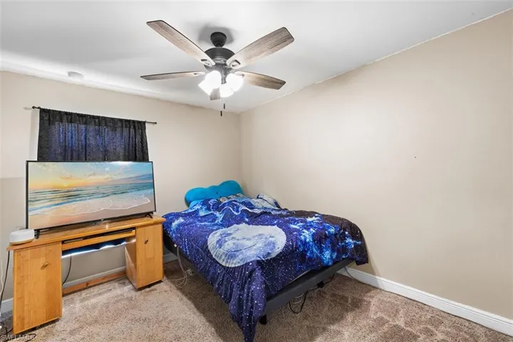 Carpeted bedroom featuring baseboards and a ceiling fan
