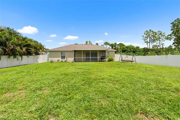 Rear view of property with a fenced backyard