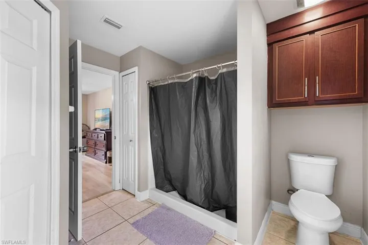 Full bathroom with light tile patterned floors and a shower stall