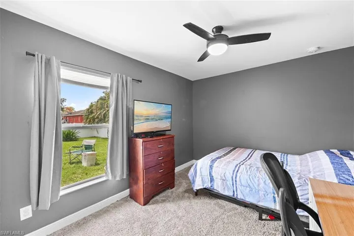 Bedroom with light colored carpet and a ceiling fan