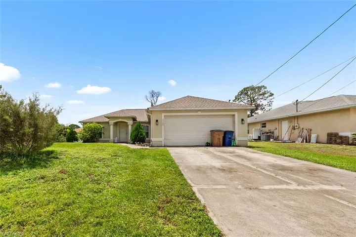 Ranch-style home featuring stucco siding, concrete driveway, a front yard, and a garage