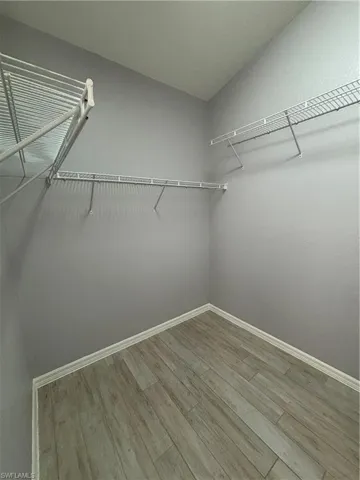 Walk in closet with light wood-style tile floors