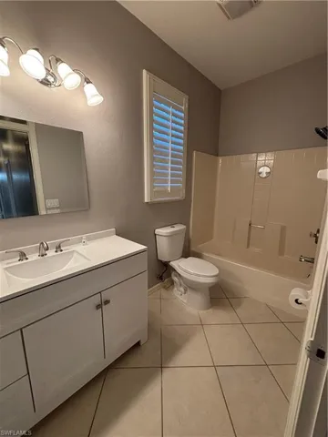 Full Pool Bathroom featuring new vanity, mirror, and toilet.  Shower / tub combination, plantation shutters and exit door to the lanai