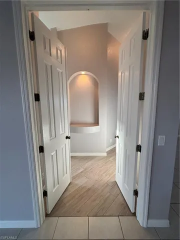 Double door entry into the primary suite featuring plank tile wood look flooring