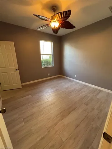 Light wood-style tile floors and ceiling fan