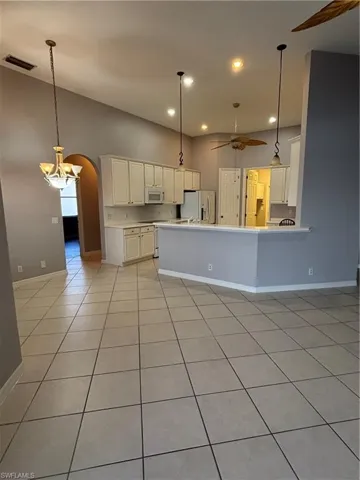 View looking into the kitchen, and the arched hallway entry to the 3 bedrooms and 2 full bathrooms