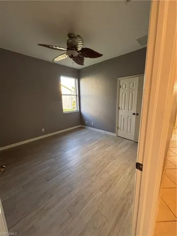 Bedroom with a ceiling fan and light wood like tile floors