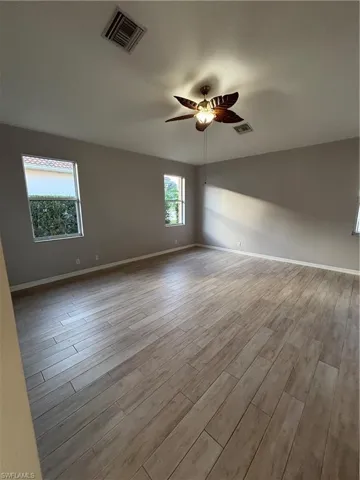 Spacious Primary bedroom featuring a ceiling fan and light wood-style tile floors