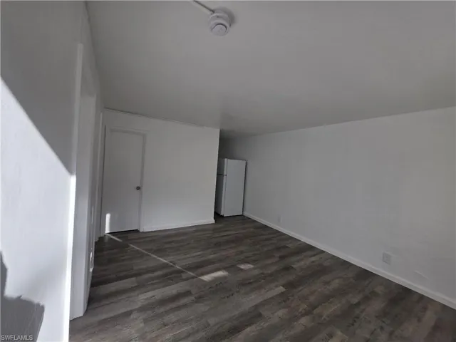 Additional living space featuring dark wood-style floors
