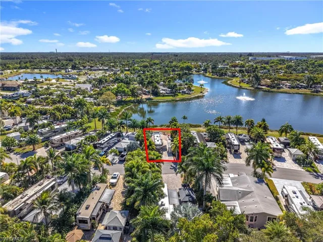 Aerial view of property and surrounding area featuring a nearby body of water, property parcel outlined, and nearby suburban area