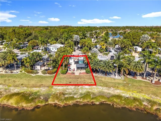 Aerial perspective of suburban area with property boundaries highlighted and a large body of water