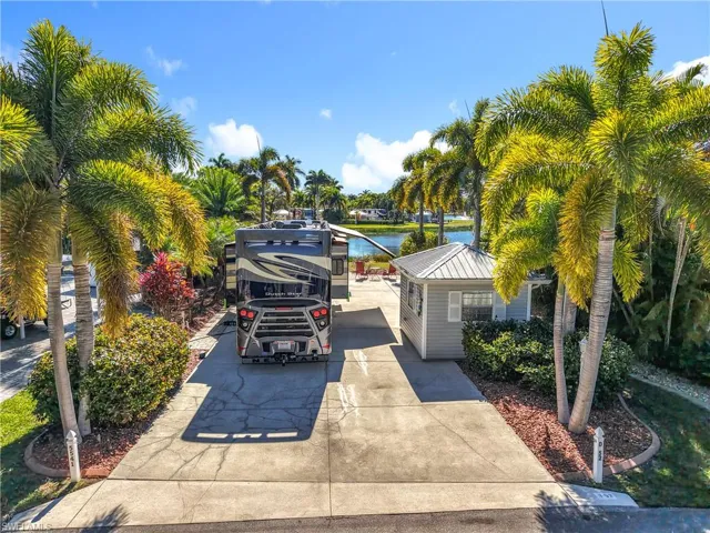 View of parking with a water view and driveway