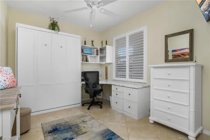 Office with a ceiling fan and light tile patterned floors
