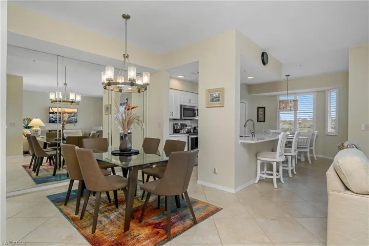 Dining space with baseboards, a notable chandelier, and light tile patterned floors
