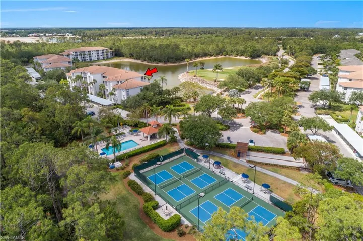 Drone / aerial view with a view of trees, a water view, and golf course view