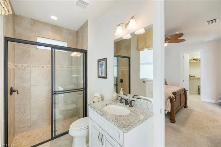 Bathroom featuring a shower stall, vanity, light carpet, recessed lighting, and a ceiling fan