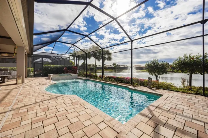 View of pool featuring a sunroom, a lanai, a patio area, and a pool with connected hot tub