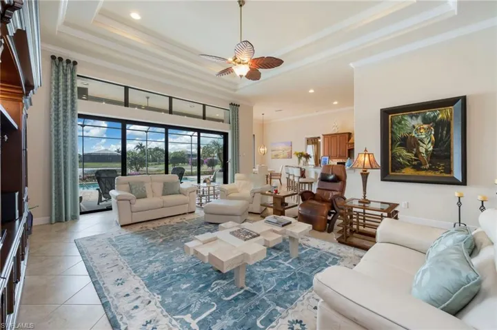 Living area with ceiling fan, recessed lighting, crown molding, a towering ceiling, and light tile patterned floors