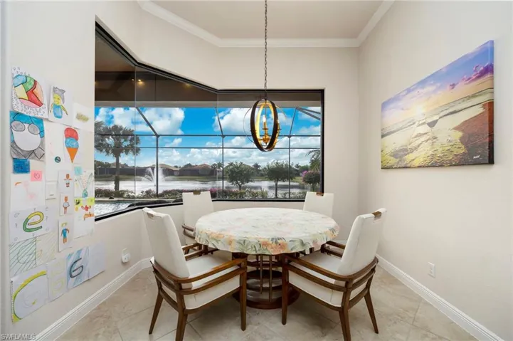 Dining area with ornamental molding and a chandelier