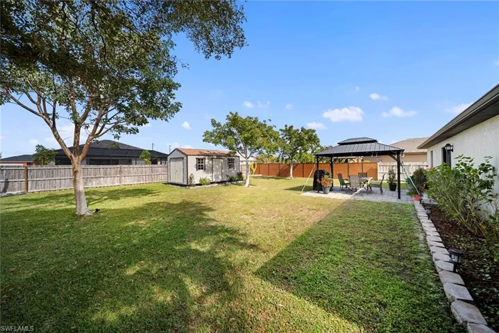Fenced backyard with a patio, a gazebo, and a storage shed