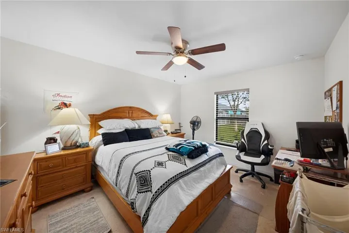 Bedroom with a ceiling fan and light colored carpet