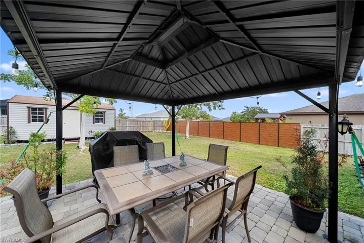 Fenced backyard featuring outdoor dining area, a patio area, and grilling area