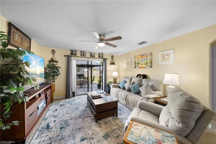 Living room with ceiling fan and baseboards