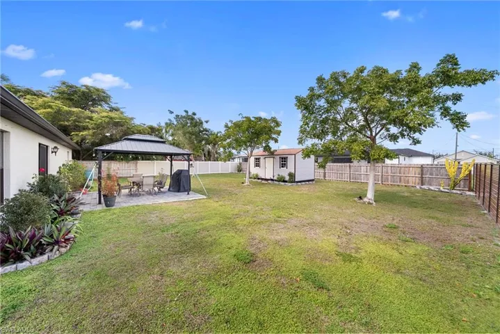Fenced backyard with a gazebo, a patio, and a shed